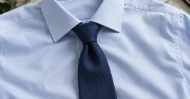 Tmavomodrá kravata s drobným asymetrickým uzlem na světlemodré košili